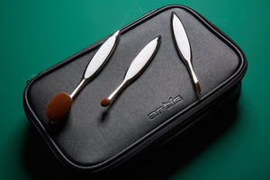 this is an image of the Large Travel Case in black and has three elite brushes laid on top, the oval 6, linear 1 and circle 1r
